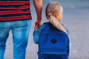 Bimba che cammina mano nella mano con il papà