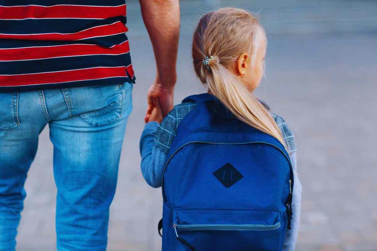 Bimba che cammina mano nella mano con il papà