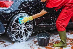 Persona che insapona i cerchi dell'auto