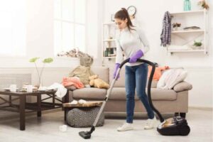 Donna pulisce casa con l'aspirapolvere