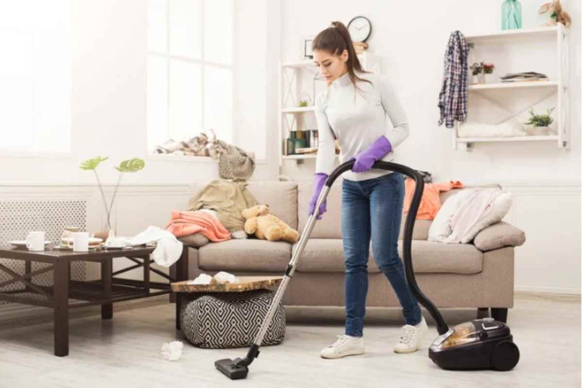 Donna pulisce casa con l'aspirapolvere 