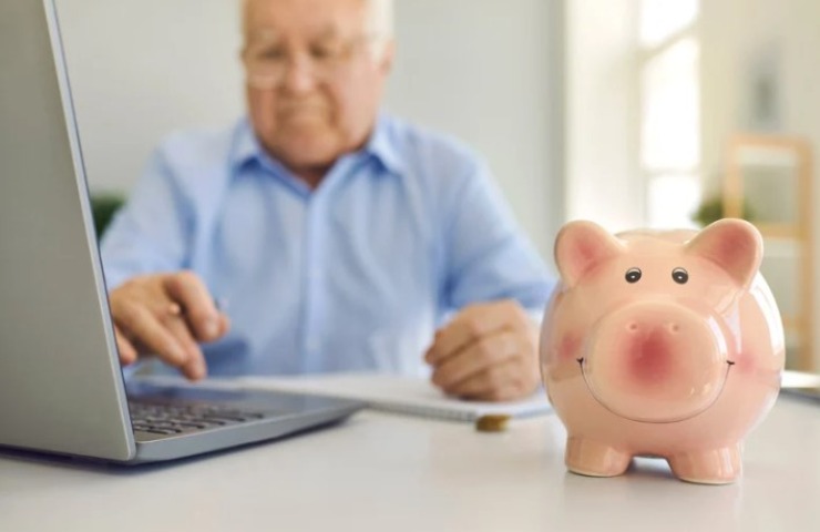 pensionato al pc con un salvadanaio 